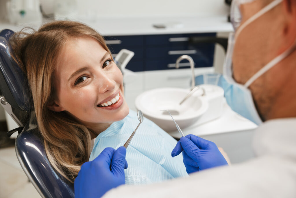 Image of european woman sitting in dental chair while profession